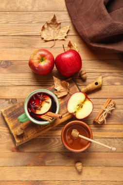 Elmalı sıcak şarap ve ahşap arka planda bal.