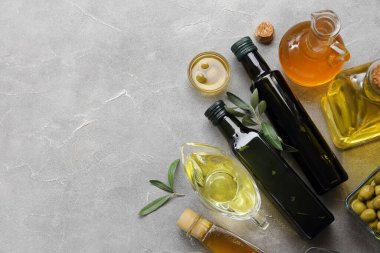 Gri zemin üzerinde taze zeytin yağı olan farklı cam kaplama.