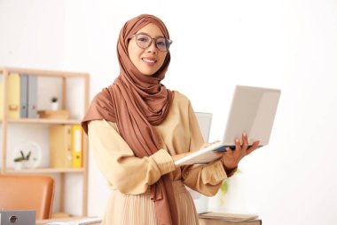 Ofiste dizüstü bilgisayarlı güzel Asyalı kadın.