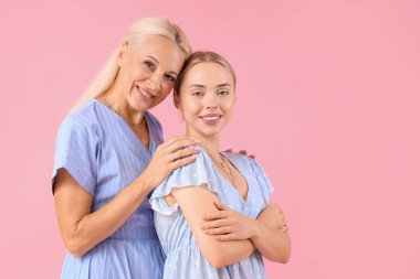 Pembe arka planda annesi olan mutlu genç bir kadın.