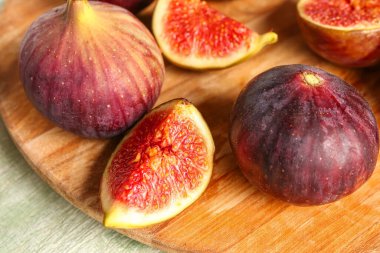 Tahta tahta tahta, yeşil ahşap arka planda taze incir.