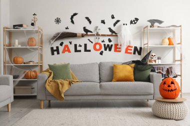 Cadılar Bayramı için dekore edilmiş oturma odasının içi kanepe ve raf üniteleriyle dolu.