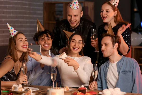 Group of young friends with mobile phone celebrating Birthday at night