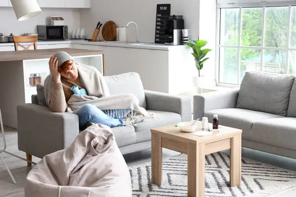 stock image Ill young man with hot water bottle at home