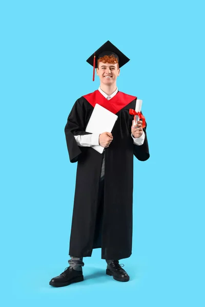 Mężczyzna Absolwent Student Dyplomem Laptop Niebieskim Tle — Zdjęcie stockowe