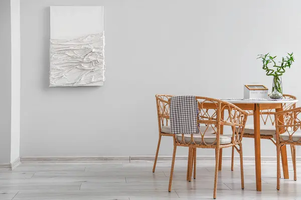 Interior of modern dining room with painting, table and chairs
