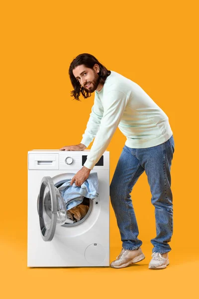 노란색 배경에 세탁기에 세탁을 — 스톡 사진
