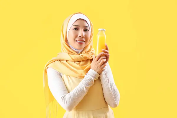 Schöne Junge Asiatin Hijab Mit Einer Flasche Saft Auf Gelbem — Stockfoto