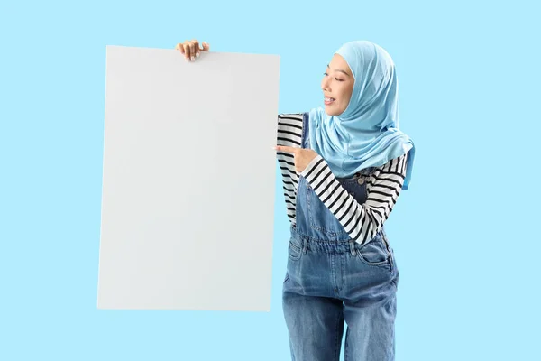 Schöne Junge Asiatin Hijab Zeigt Auf Leeres Plakat Auf Blauem — Stockfoto
