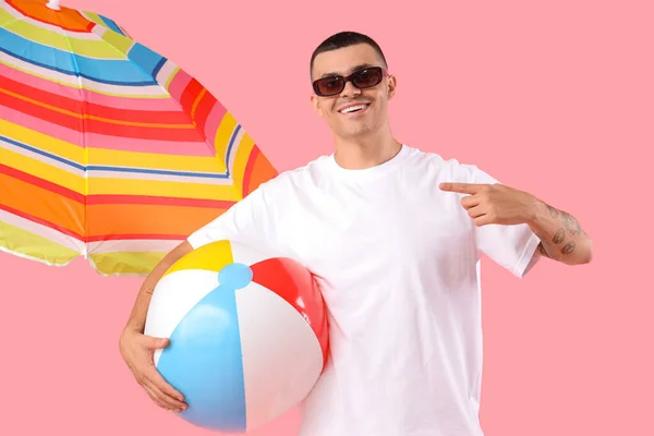 Happy Young Man Umbrella Pointing Inflatable Ball Pink Background — Stock Photo, Image