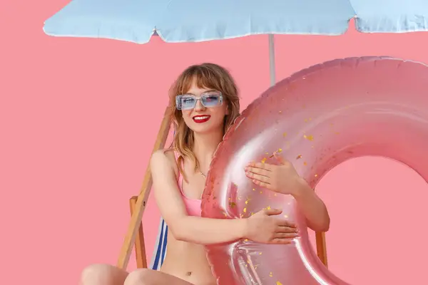 Junge Frau Liegestuhl Mit Sonnenschirm Und Schwimmring Auf Rosa Hintergrund — Stockfoto