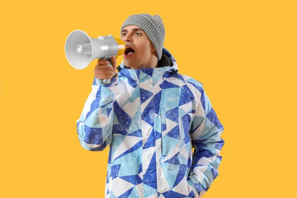 Junger Mann Winterkleidung Ruft Megafon Auf Gelbem Hintergrund — Stockfoto