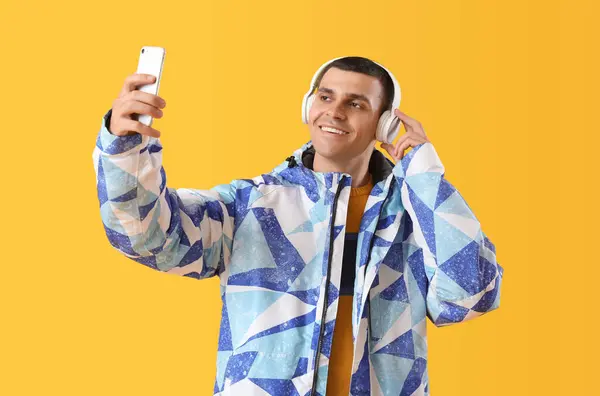 Giovane Giacca Calda Con Cuffie Scattare Selfie Sfondo Giallo — Foto Stock