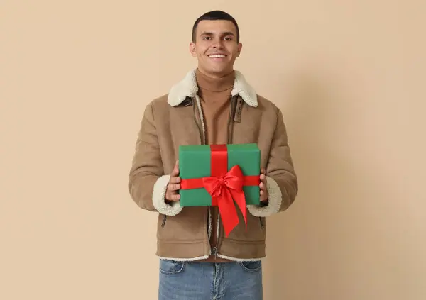 Young Man Sheepskin Jacket Christmas Gift Beige Background — Stock Photo, Image