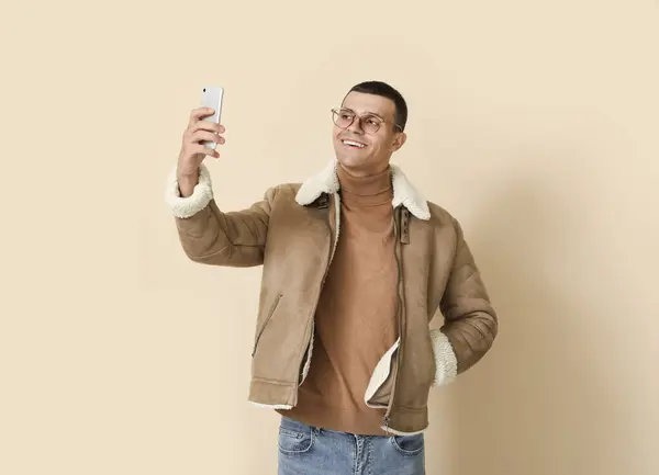 Young Man Sheepskin Jacket Mobile Phone Beige Background — Stock Photo, Image