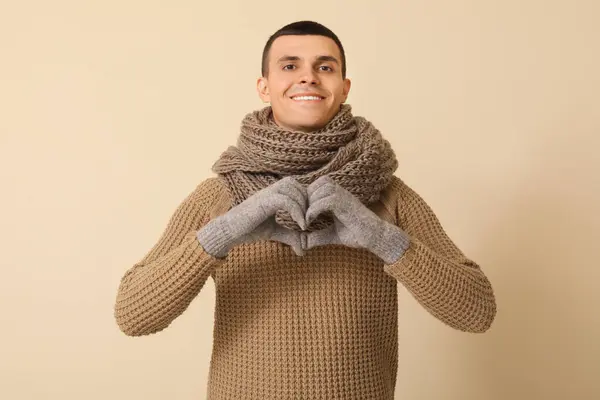 Νεαρός Άνδρας Χειμωνιάτικα Ρούχα Κάνει Χειρονομία Καρδιάς Μπεζ Φόντο — Φωτογραφία Αρχείου