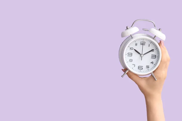 Female Hand Holding Alarm Clock Lilac Background — Stock Photo, Image