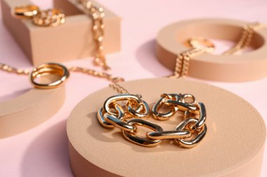 Pembe arka planda güzel mücevherleri olan dekoratif podyumlar.