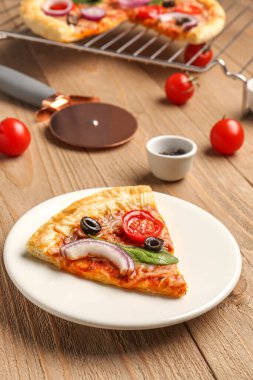 Tabak dilimlenmiş ve ahşap arka planda lezzetli pizza standı.