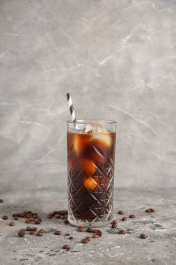 Duvarın yanındaki grunge masasında saman ve fasulyeli buzlu kahve.