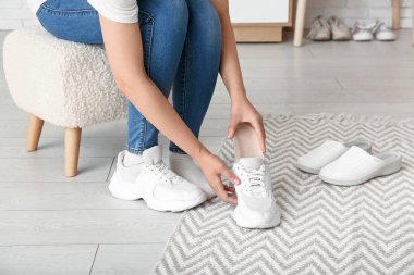 Kadın evde spor ayakkabısına ortopedik taban takıyor.
