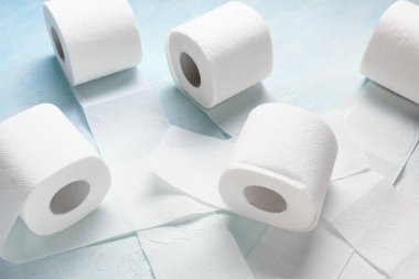 Açık mavi arkaplanda tuvalet kağıdı ruloları