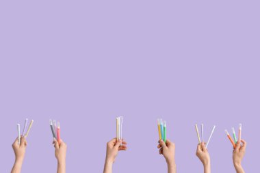 Hands with school supplies on lilac background