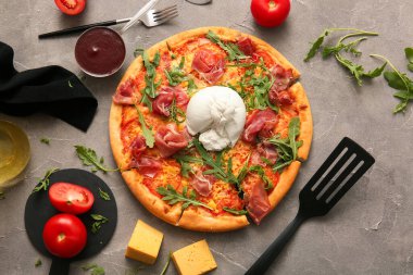 Gri arka planda Burrata peynirli lezzetli pizza.
