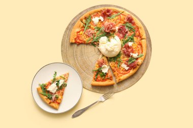 Tahta tahta tahta ve sarı arka planda Burrata peyniri olan lezzetli bir tabak pizza.