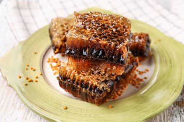 Hafif ahşap arka planda bal petekleri olan bir tabak.