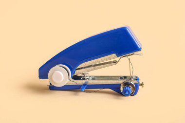 Bej arkaplanda elle dikiş makinesi