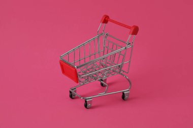 Pembe arka planda alışveriş arabası
