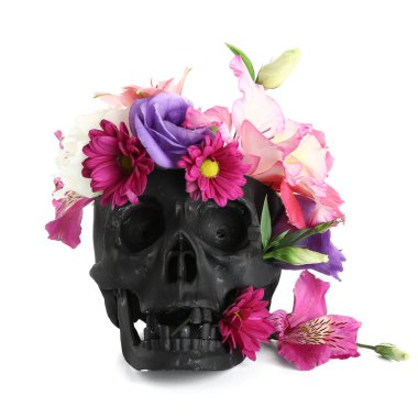 Beyaz arka planda güzel çiçekler olan siyah insan kafatası.