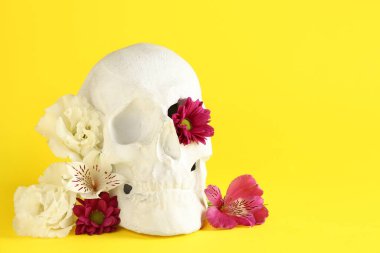Sarı arka planda güzel çiçekli insan kafatası