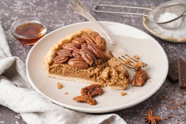 Gri arka planda bir parça lezzetli cevizli turta.