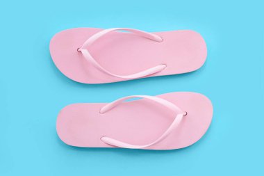 Mavi arka planda pembe parmak arası terlikler.