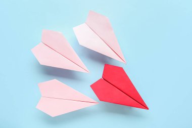 Mavi arkaplanda renkli origami kağıt uçaklar