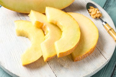 Mavi ahşap arka planda tatlı kavun parçaları olan tahta.