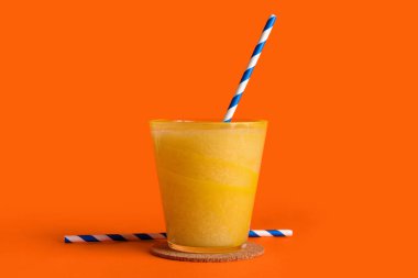 Turuncu arka planda bir bardak lezzetli kavun püresi.