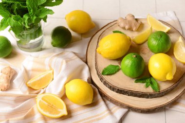 Beyaz fayans zemininde limonata hazırlamak için malzemeler içeren ahşap tahta tahta.