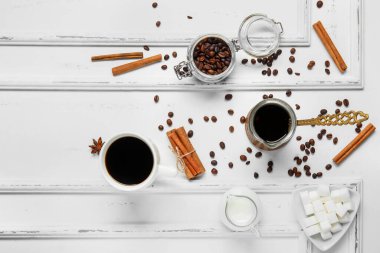 Beyaz ahşap arka planda tarçınlı, sütlü, şekerli, fasulyeli bir fincan lezzetli kahve.