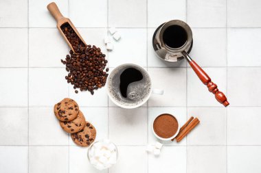 Beyaz fayanslı tarçın, şeker, fasulye ve kurabiyeli bir fincan lezzetli kahve.