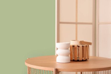 Dekorlu ahşap sehpa ve yeşil duvarın yanında katlanır ekran.