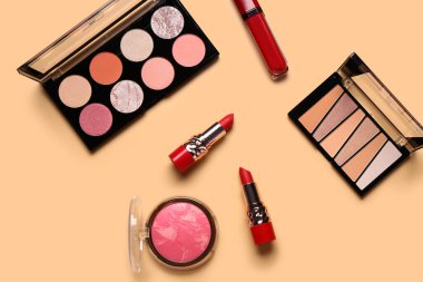 Güzel göz falı paletleri ve turuncu arka planda farklı dekoratif kozmetikler.