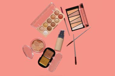 Güzel göz falı paletleri ve pembe arka planda farklı dekoratif kozmetikler.