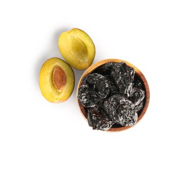 Beyaz arka planda lezzetli kurutulmuş erikli ahşap kase.