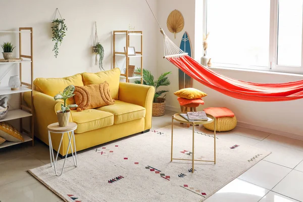 有红色吊床 黄色沙发和咖啡桌的时尚客厅室内 — 图库照片