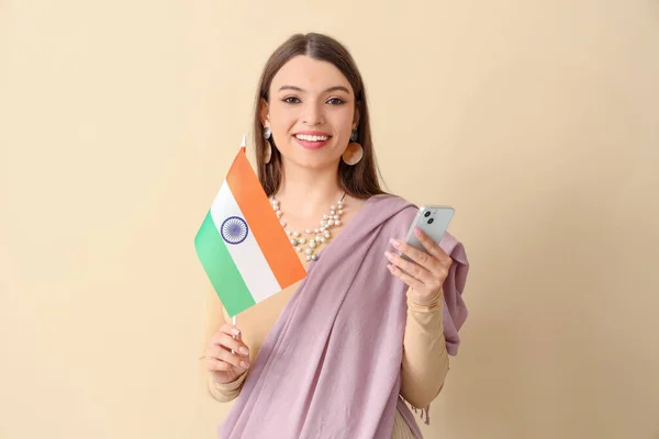 Junge Frau Mit Indianerfahne Und Handy Auf Beigem Hintergrund — Stockfoto