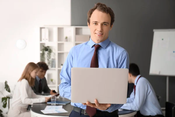 Male business consultant working with laptop in office