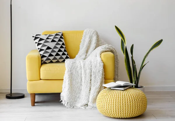 Oturma odasının içinde yastıklı ve ekoseli sarı koltuk